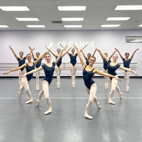 Senior ballet students posing in a heart shape.